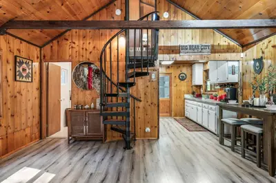 a spiral staircase in a kitchen with wooden walls at The RobinHood Retreat! A 1 min Walk to SnowPlay! in Big Bear City
