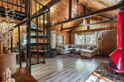 a living room with wooden walls and wooden floors at The RobinHood Retreat! A 1 min Walk to SnowPlay! in Big Bear City