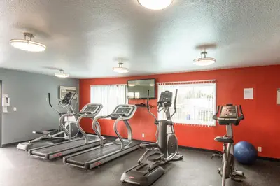 a gym with several exercise bikes and red walls at Skyline Terrace Executive Jr One Bedroom with Balcony and Pool in Los Angeles