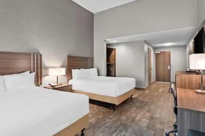 a hotel room with two beds and a desk at Best Western San Bernardino Hotel in San Bernardino