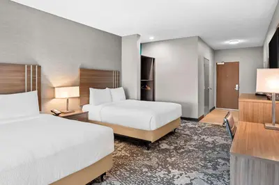 a hotel room with two beds and a television at Best Western San Bernardino Hotel in San Bernardino
