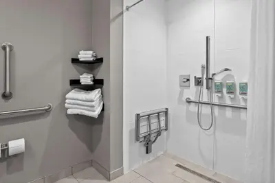 a bathroom with a shower and some towels at Best Western San Bernardino Hotel in San Bernardino