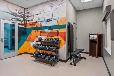 a gym with dumbbells and a painting on the wall at Best Western San Bernardino Hotel in San Bernardino
