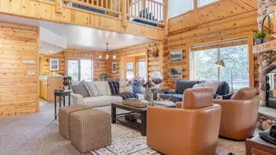 a living room with wooden walls and furniture in a cabin at Tanglewood by AvantStay 10mins to Bear Mountain Contemporary Hillside Cabin in Big Bear Lake