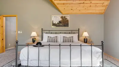 a bedroom with a large bed and two lamps at Tanglewood by AvantStay 10mins to Bear Mountain Contemporary Hillside Cabin in Big Bear Lake