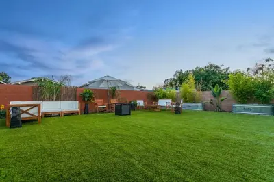 a backyard with a lawn with benches and tables at Gameroom Sofi Stadium Forum Backyard BBQ in Hawthorne