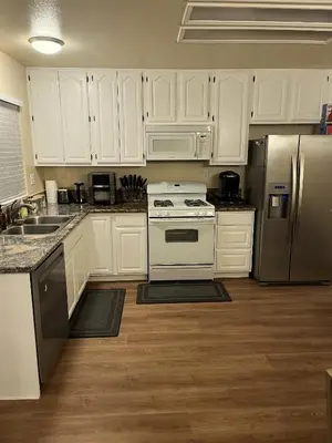 a kitchen with white cabinets and stainless steel appliances at Cozy Family Home - 20 Mins from Disneyland in Placentia