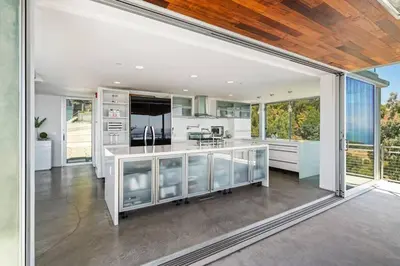 a kitchen with white appliances and a large window at Malibu Glass House: Architectural w 180deg Views in Malibu