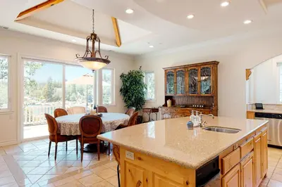 a kitchen with a large island and a table with chairs at Bayfront Beauty - Main in Lake Arrowhead