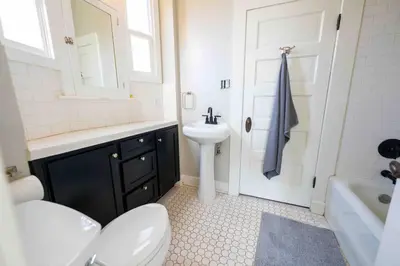 a bathroom with a white toilet and a sink at Downtown 3 bed newly renovated with amenities. in Bakersfield