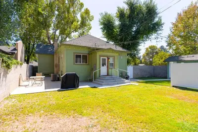 a small green house with a lawn in front of it at Downtown 3 bed newly renovated with amenities. in Bakersfield