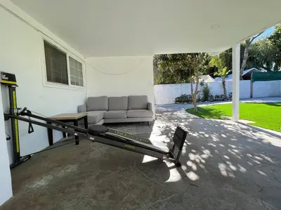 a patio with a couch and a bench in a house at Modern 4 King Beds, Beautiful Large Backyard, Golf, WFH, Long Stays, WI-FI, FWY, 25 mins to Beach in Casa Conejo