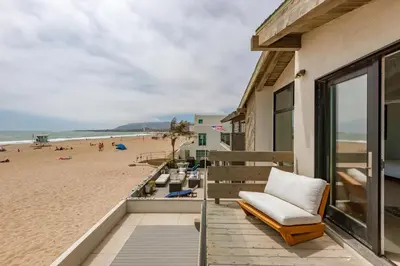 a view of the beach from the balcony of a beach house at Luxury Modern Designer Beach House on Sand w/ Pool in Ventura