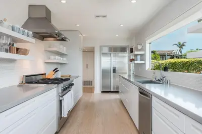 a kitchen with white counters and a large window at Luxury Modern Designer Beach House on Sand w/ Pool in Ventura