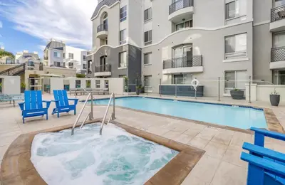 a swimming pool with blue chairs next to a building at The Nest a Spacious 1 Bedroom Apartment with a Pool View in Los Angeles