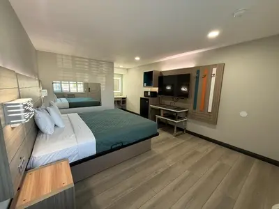 a bedroom with a bed and a desk and a television at Rosemead Motel in Rosemead