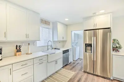 a kitchen with white cabinets and a stainless steel refrigerator at Super Walkable! Historic Home in Dtwn Long Beach in Long Beach
