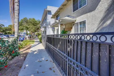 a house with a iron fence next to a sidewalk at Super Walkable! Historic Home in Dtwn Long Beach in Long Beach