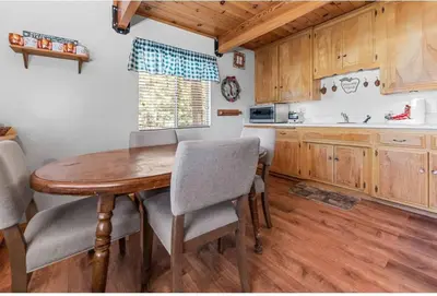 a kitchen with a wooden table and chairs at Paradise Cabin in Big Bear City