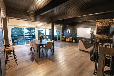 a dining room and living room with a table and chairs at Updated Mountain Cabin Retreat with 180 views off Deck and Balcony in Running Springs