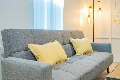 a blue couch with yellow pillows in a living room at Stylish 2B2B country style house in Glendora