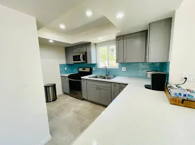 a kitchen with gray cabinets and a sink at Luxury home near Disney land. Entire place! in Orange