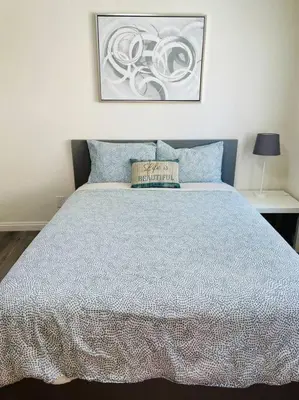 a bedroom with a bed with a blue comforter at Luxury home near Disney land. Entire place! in Orange