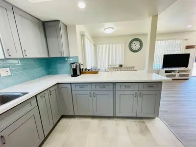a kitchen with white cabinets and a clock on the wall at Luxury home near Disney land. Entire place! in Orange