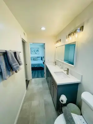 a bathroom with a sink and a toilet and a mirror at Luxury home near Disney land. Entire place! in Orange