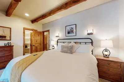 a bedroom with a large white bed with a wooden headboard at Arrowhead Haven in Lake Arrowhead