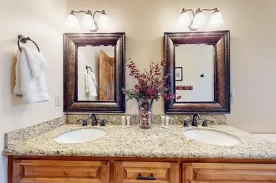 a bathroom with two sinks and two mirrors at Arrowhead Haven in Lake Arrowhead