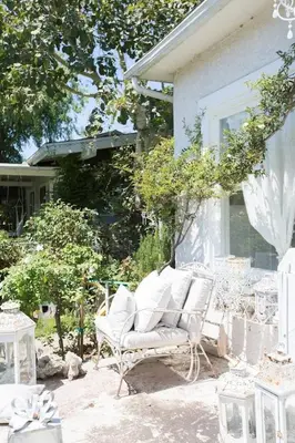 a white chair sitting on a patio next to a house at Elegant White Cottage, Venice Beach, California in Los Angeles