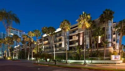 a building with palm trees in front of a street at Exclusive Suites in MDR-Venice with Pool, GYM & HotTub in Los Angeles