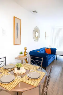 a living room with a table and a blue couch at Exclusive Suites in MDR-Venice with Pool, GYM & HotTub in Los Angeles