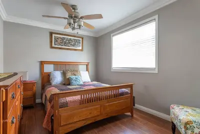 a bedroom with a wooden bed and a window at Amazing BBQ POOl home at center of LA\u7f8e\u5f0f\u56db\u623f\u5927\u5730\u6cf3\u6c60\u70e7\u70e4\u533a\u7f8e\u5c4b in Chino Hills