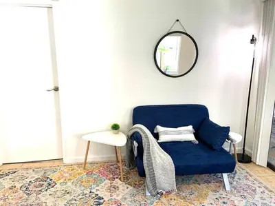 a blue chair in a room with a table and a mirror at Garden Suite - 10 mins to Beach and LAX in Gardena