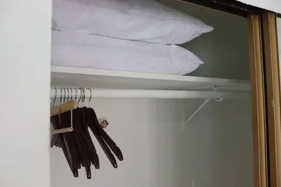a closet with a bed and some pillows at Garden Suite - 10 mins to Beach and LAX in Gardena