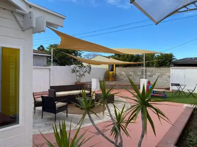 a patio with a table and chairs and an umbrella at Garden Suite - 10 mins to Beach and LAX in Gardena