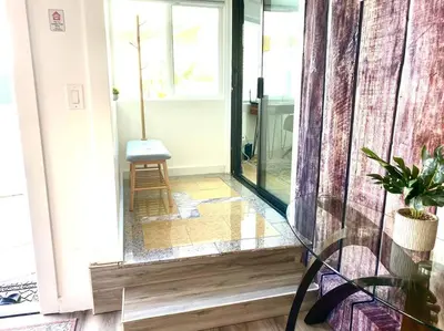 a glass door to a room with a chair in it at Garden Suite - 10 mins to Beach and LAX in Gardena