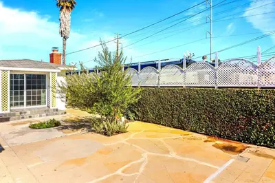 a house with a fence and a palm tree at Luxury Home - 7mins LAX/Beach, 405/SoFi nearby in Hawthorne
