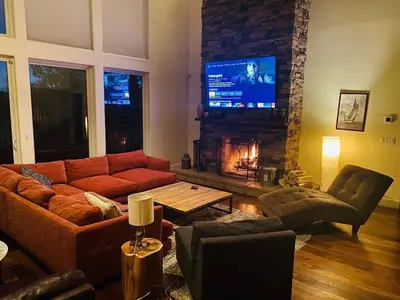 a living room with a couch and a fireplace at Modern 6 bedroom retreat, stunning lake views, close to village! in Lake Arrowhead