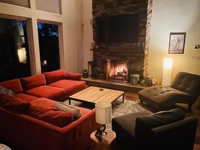 a living room with a couch and a fireplace at Modern 6 bedroom retreat, stunning lake views, close to village! in Lake Arrowhead