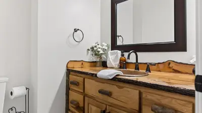 a bathroom with a wooden sink and a mirror at Honeypot by AvantStay Indoor Pool Hot Tub in Big Bear Lake