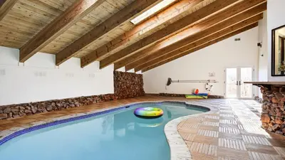 a swimming pool in a room with wooden ceilings at Honeypot by AvantStay Indoor Pool Hot Tub in Big Bear Lake