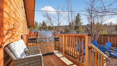 a patio with a grill and chairs on a deck at Honeypot by AvantStay Indoor Pool Hot Tub in Big Bear Lake