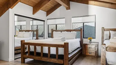 two beds in a room with windows at Honeypot by AvantStay Indoor Pool Hot Tub in Big Bear Lake