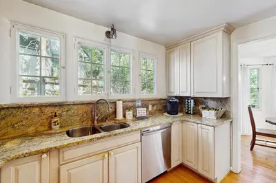 a kitchen with white cabinets and a sink at Vintage Village Walk Cottage in Lake Arrowhead