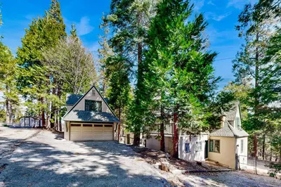 a home in the woods with a driveway at Vintage Village Walk Cottage in Lake Arrowhead