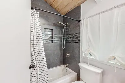 a bathroom with a white toilet and a shower at Saint Bernard Beauty in Lake Arrowhead