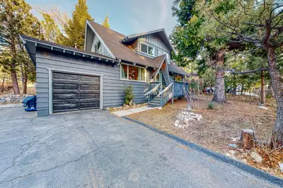 a blue house with a garage and a driveway at Saint Bernard Beauty in Lake Arrowhead